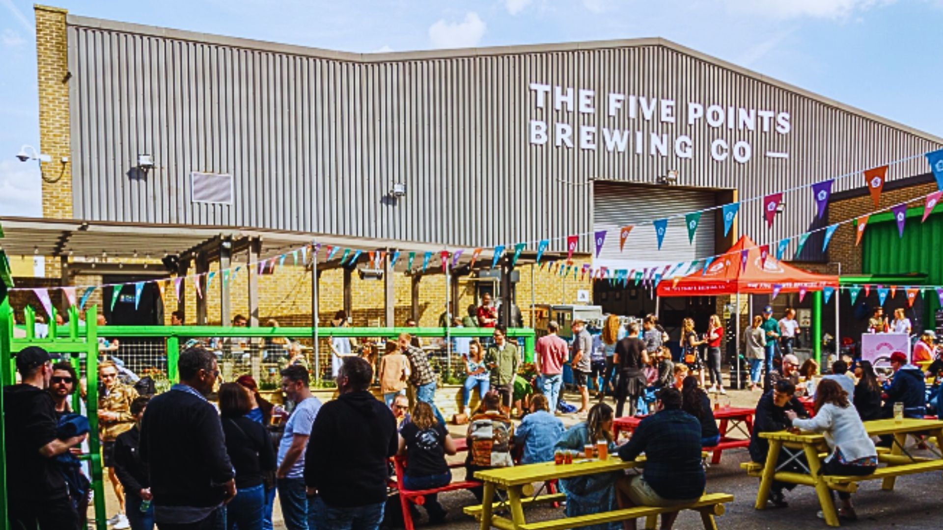 an image of the exterior brewery with bunting and benches