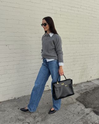 Influencer wearing a gray sweater, jeans, and Loro Piana Rebecca flats