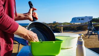 how to clean camping cookware: cleaning pans at a campsite