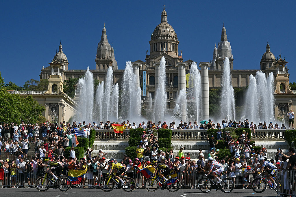 Team Visma | Lease a Bike's Danish rider Jonas Vingegaard wearing the overall leader's yellow jersey and riders cycle past Montjuic Palace during the 2nd stage of the 113th edition of the Tour de France cycling race, 168,5 km between Tarragona and Barcelona in northeastern Spain, on July 5, 2026. (Photo by Loic VENANCE / AFP via Getty Images)