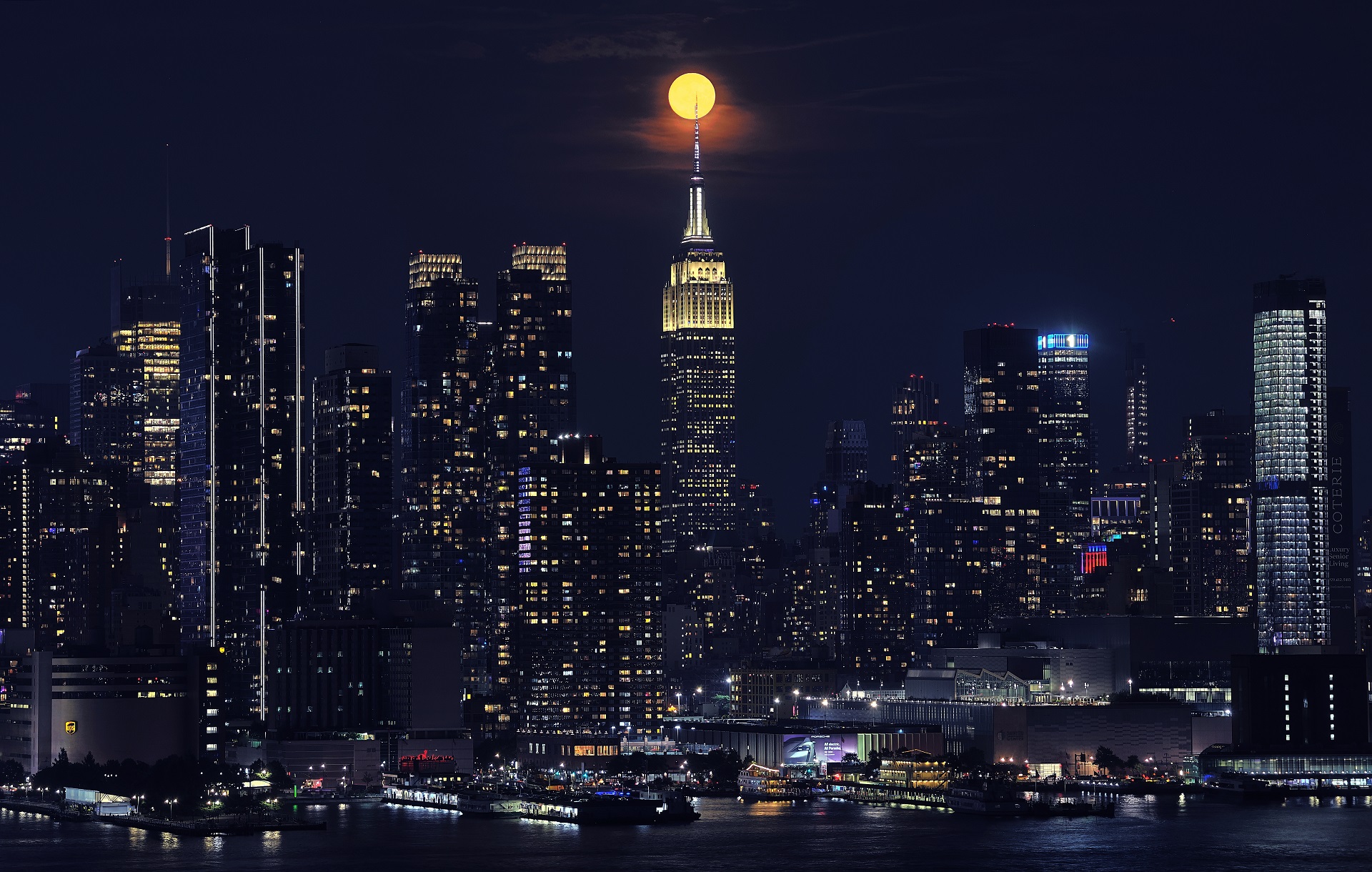 The full Strawberry Moon rises behind the Empire State Building in New York City on June 21, 2024, as seen from Weehawken, New Jersey.
