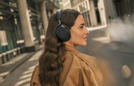 A woman wearing the new Jabra Evolve3 headset in a busy street.