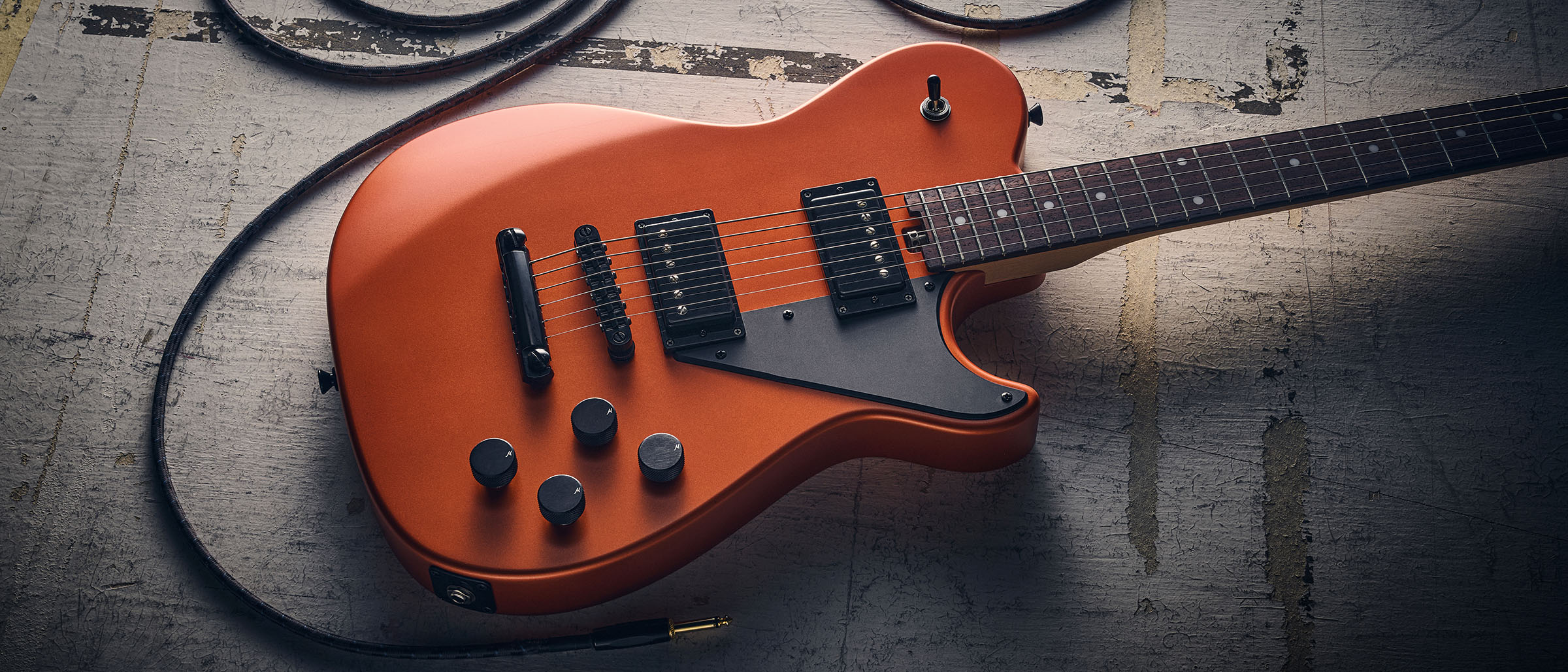 Manson MD-3 Mikey Demus Signature: the hot-orange T-style is photographed against a distressed grey-white background