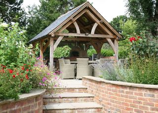 Oak frame gazebo with outdoor pizza oven, curved brick wall and steps
