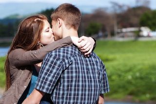 A teenage couple kissing.