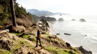 A woman hiking a secluded path along the coastline