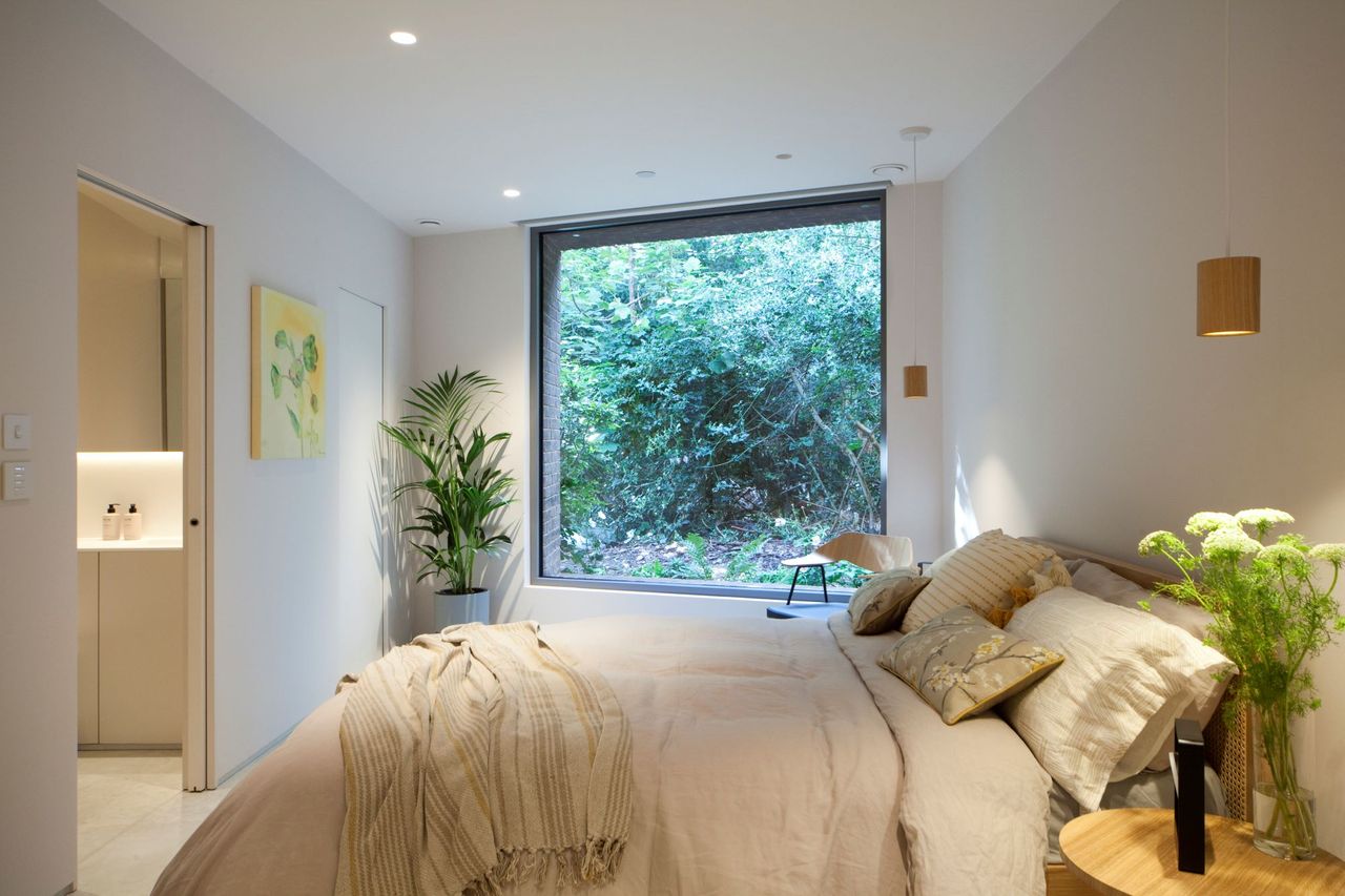 The bedroom of the triangle Grand Designs home with a large double bed