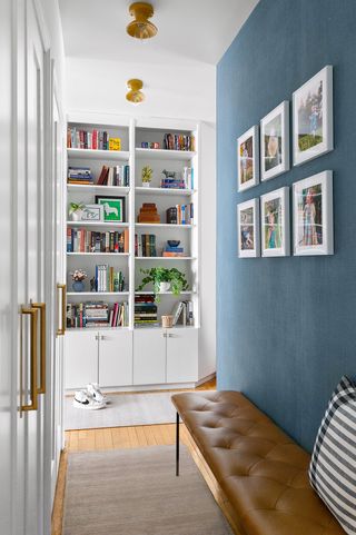 a small entryway painted blue with a bench