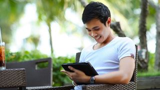 Man using an android tablet outdoors.