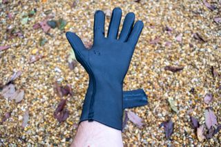 Velotoze neoprene gloves on some gravel with water droplets on them