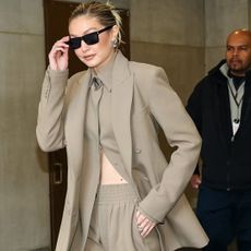 Gigi Hadid wearing a tan suit and sunglasses
