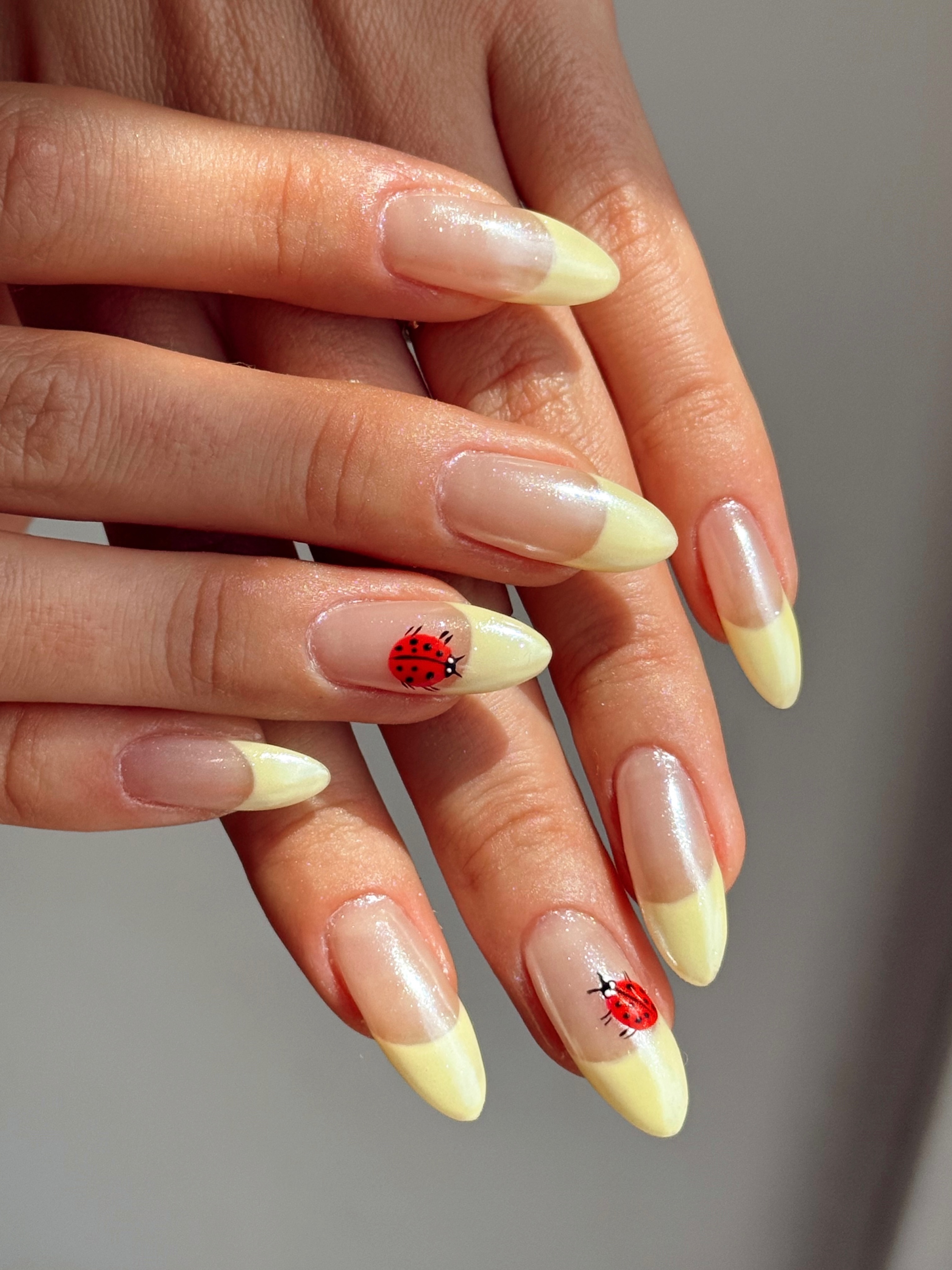 Yellow chrome French tips with ladybug art.