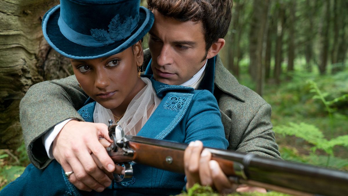 Kate Sharma (Simone Ashley) and Anthony Bridgerton (Jonathan Bailey) embrace as Anthony teaches Kate how to use a gun.