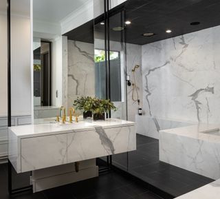 black and white bathroom with marble vanity and walls, black ceiling and black floor