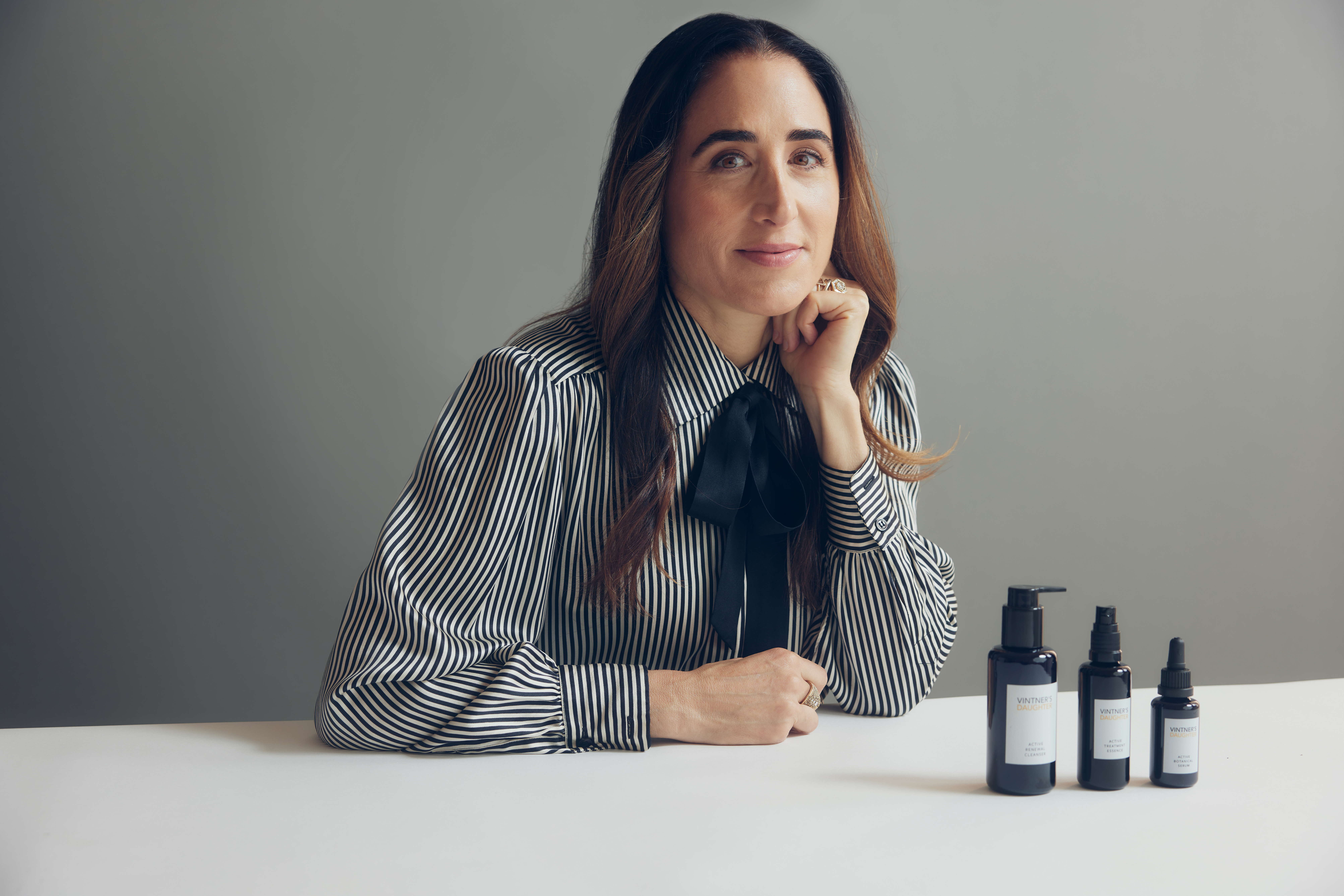 April Gargiulo, founder of Vintner's Daughter, in a striped shirt with her beauty products