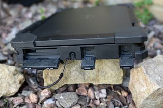 A black Dell Latitude 7330 Rugged Extreme laptop sitting on a rocky surface