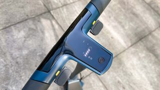 Unagi Model One Voyager battery display on handlebars shown while parked on sidewalk