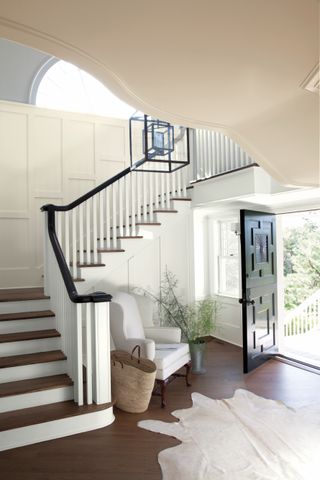 beige painted staircase with black accent handrail