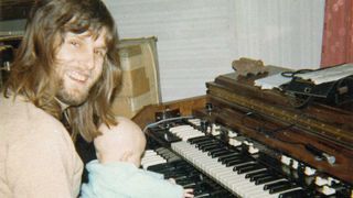 Keith Emerson at the piano with a young Aaron Emerson on his lap