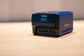 A blue and black Xulu XR1 Max mini PC on a wooden desk