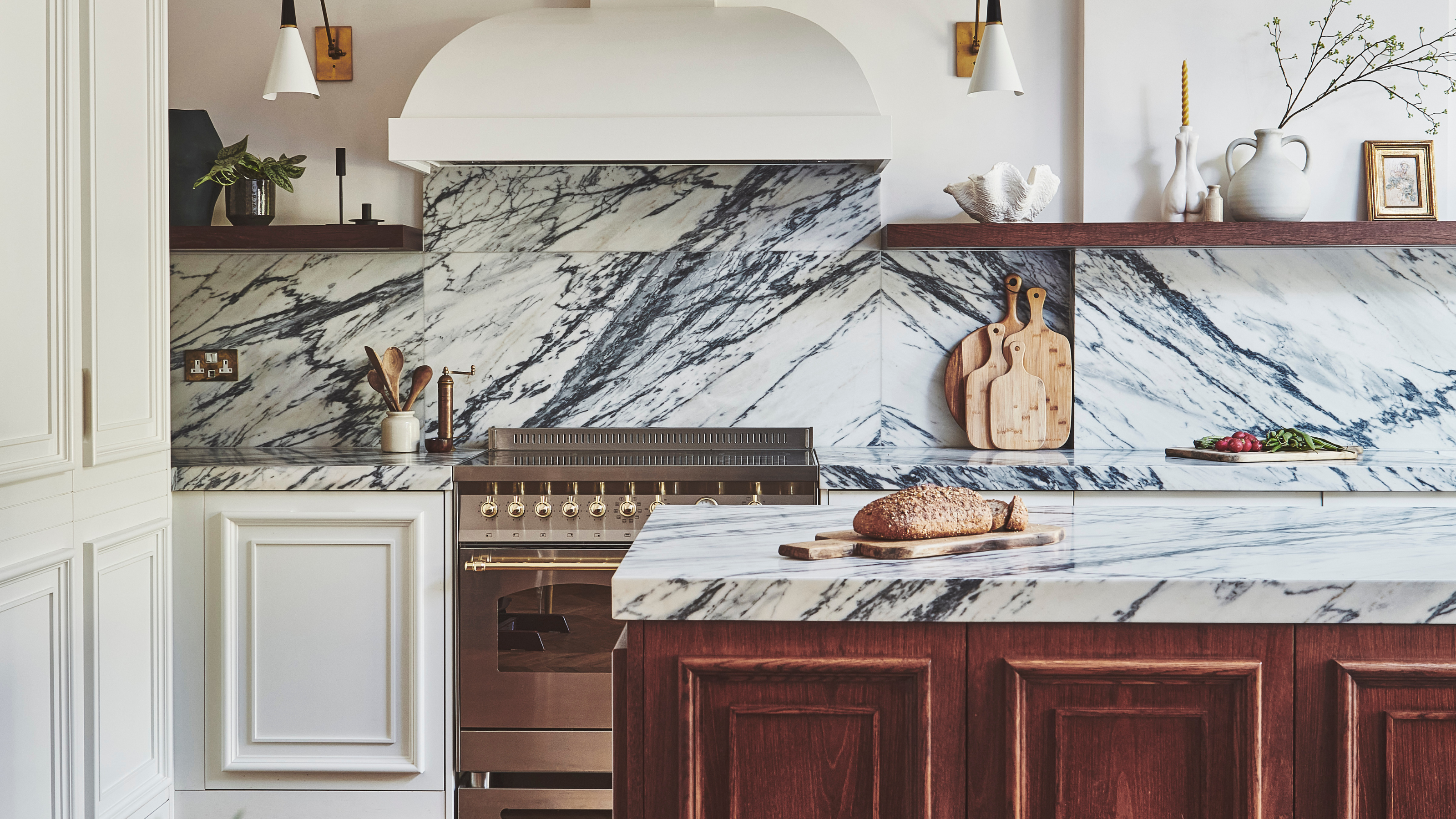 shaker style kitchen with a silver range oven and marble splash back and counters