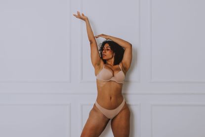 Vaginal care: Young Woman Wearing Lingerie Standing Against Wall