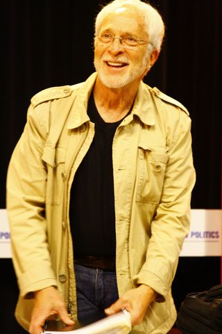 Author Lee Gutkind wearing a tan coat, black shirt and blue jeans. 