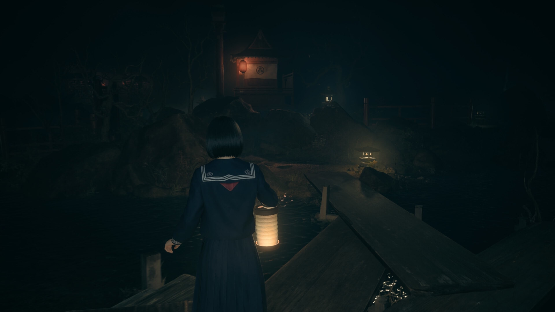 Hinako walks across wooden planks that connect jutting out bits of land in front of the dark shrine entrance in Silent Hill f