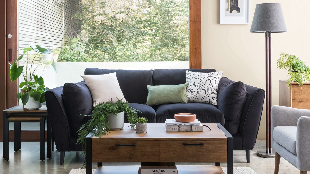 living room with dark sofa, wooden coffee table and lamp