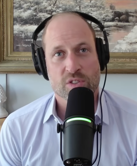 Prince William talking into a mic in front of a painting
