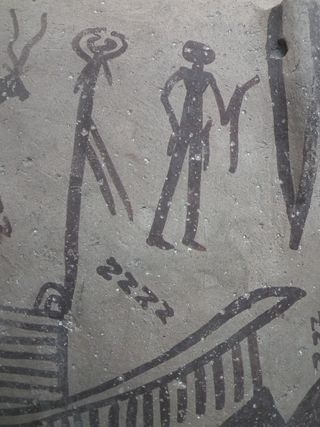 A ritual scene painted on a Predynastic pottery jar. Notice the S-shaped lines (that looks like Zs) and the curved, linear object held by the man.