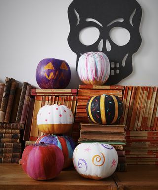 Easy no-carve pumpkin ideas with pumpkins painted in a childlike way in multiple colors