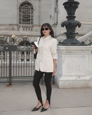 Influencer @dawn.tan wears stirrup leggings and a white shirt.