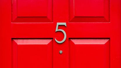 A red door with the number 5 above the peep hole.
