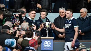 Scotland's flanker Rory Darge (L) and Scotland's fly-half Finn Russell pose with the Cuttitta Cup in front of Princess Anne at the end of the Six Nations match between Scotland and Italy