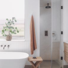 White bathroom with tub and shower room with glass door