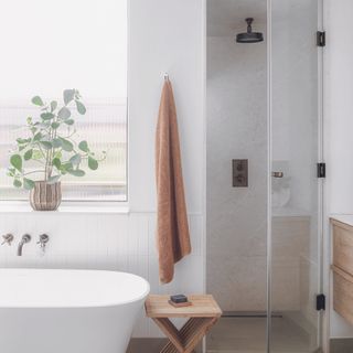 White bathroom with tub and shower room with glass door