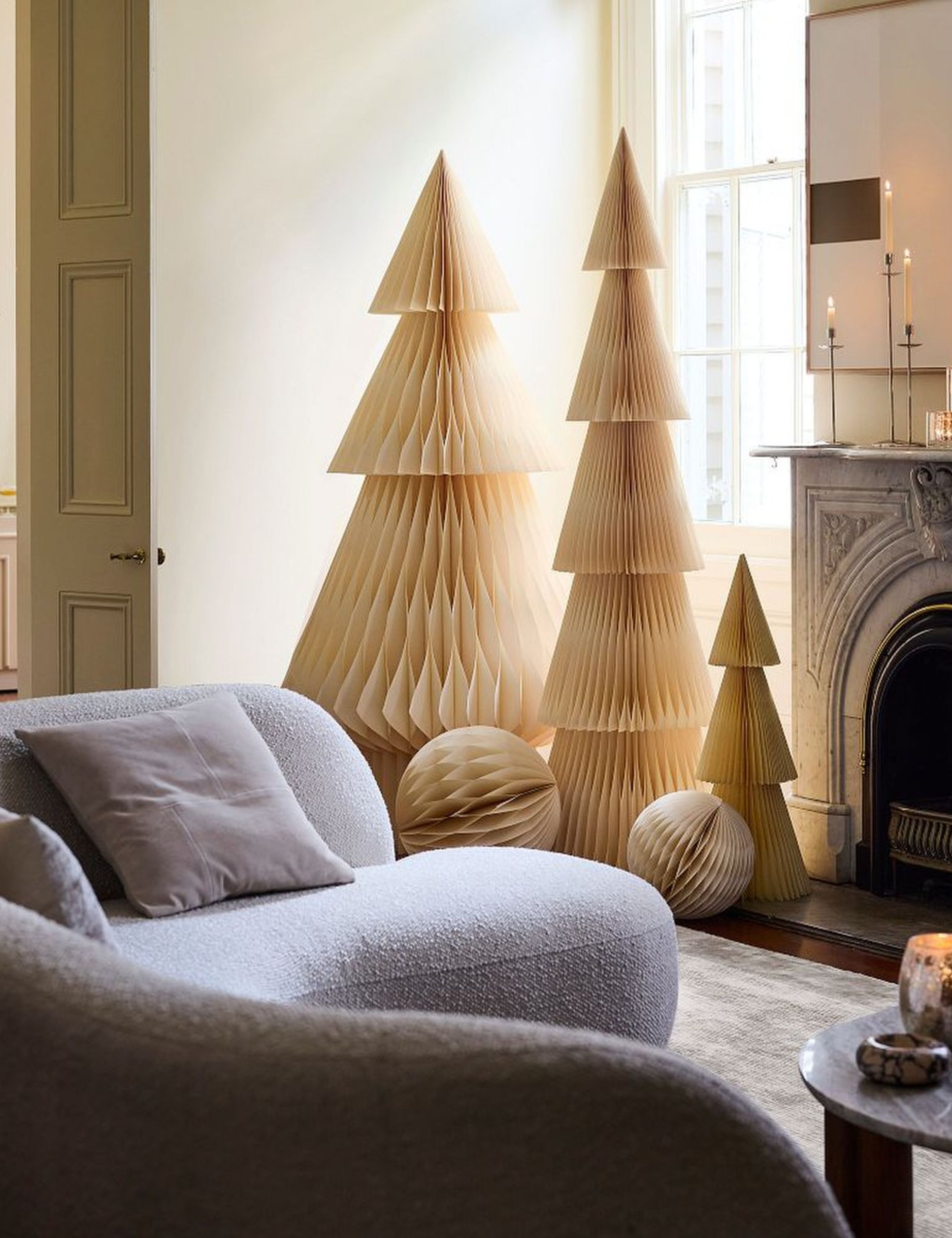 Trio of ivory paper Christmas trees styled inside of a cozy living room