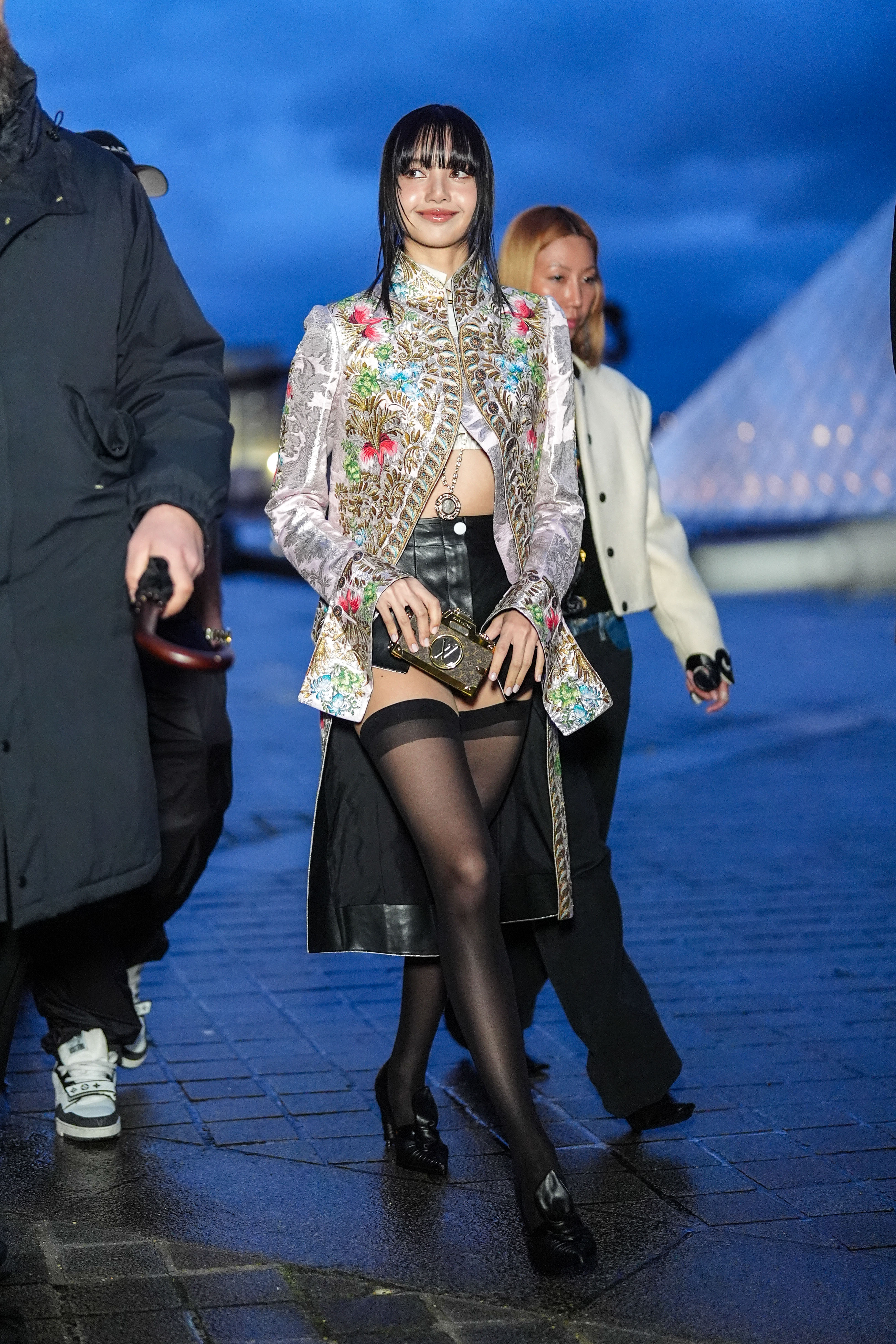 Lisa / Lalisa Manobal wears a floral print colored long jacket , black leather mini shorts, black tights, black leather pointed shoes outside Louis Vuitton, during the Womenswear Fall/Winter 2024/2025 as part of Paris Fashion Week on March 05, 2024 in Paris, France. (Photo by Edward Berthelot/Getty Images)