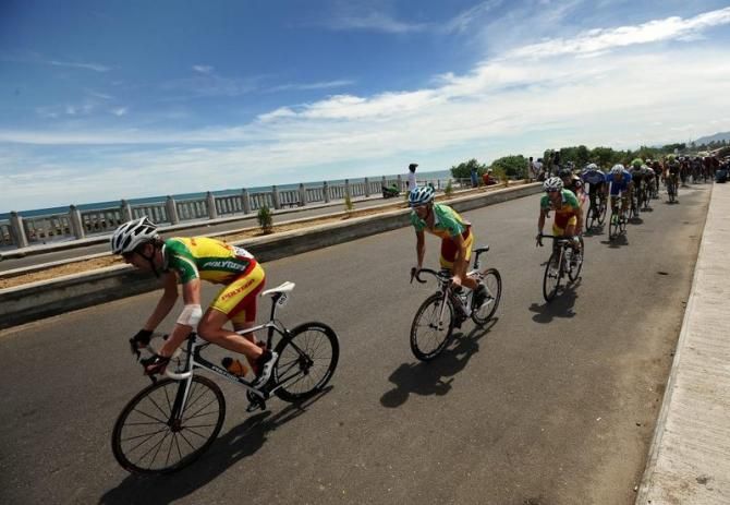 Ryan Sherlock (L) and Sergey Kuzmin (C) of Polygon Sweet Nice Cycling Team pass over the bridge alongside of Padang Beach in Stage 7 Tour de Singkarak 2013.