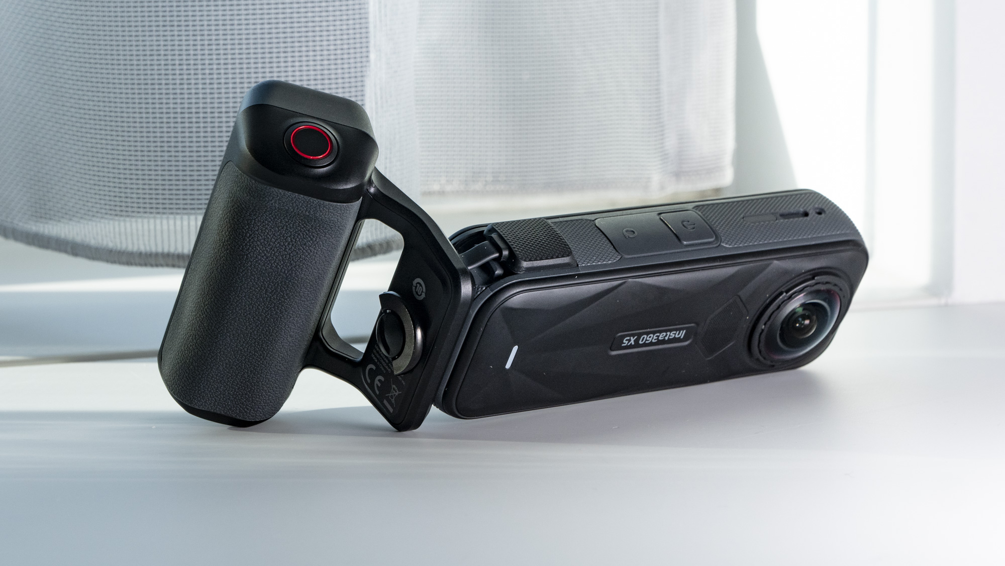 Insta360 X5 Photography Grip attached to the camera, on a plain white surface