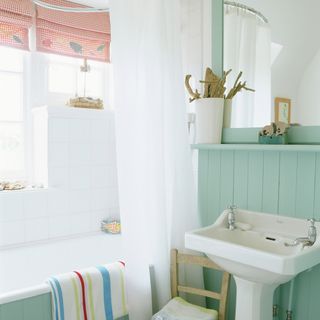 bathroom with white wash basin bath tub and white curtains