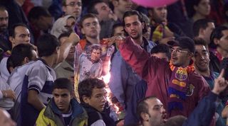 Barcelona fans burn a poster of Luis Figo at Camp Nou after his move to Real Madrid in 2000.