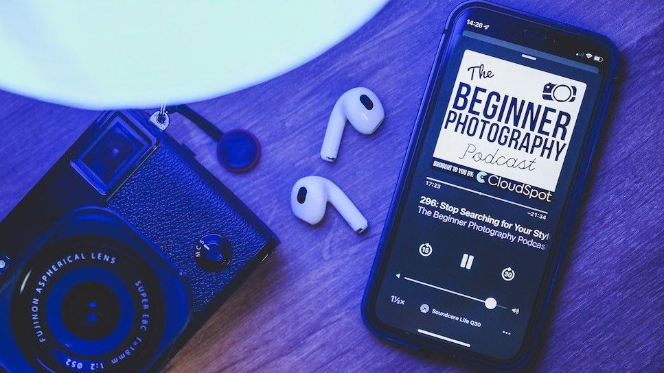 Promo graphic for Beginner Photography Podcast featuring phone, ear pods and camera on desk