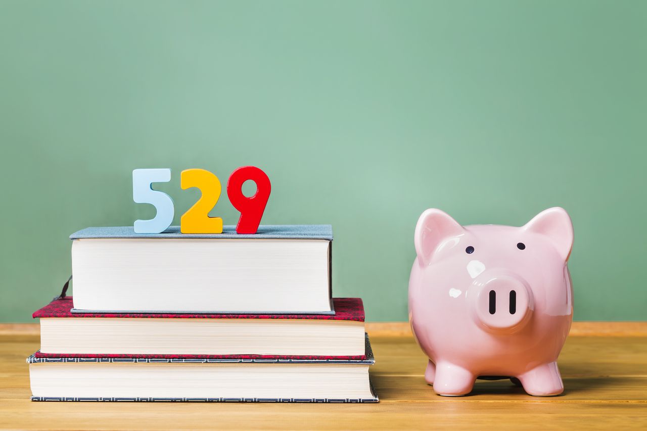 529 college savings plan theme with textbooks and piggy bank and green chalkboard background