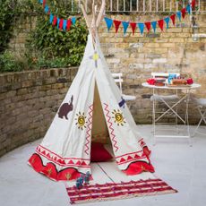 paved garden area with kids teepee and small table in background 