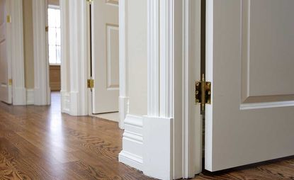 White baseboards with hardwood floors