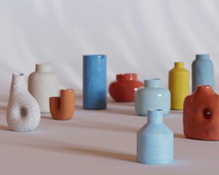 an assortment of different shaped and colored vases sat on a white background