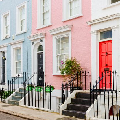 house exterior with red door and black metal railing