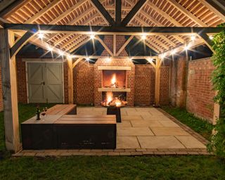 A outdoor space with pergola covering, fire pit and wooden corner bench